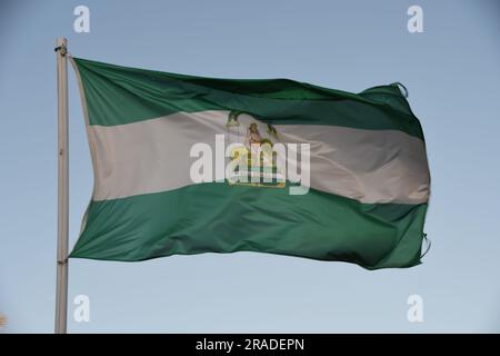 Andalusische Flagge weht im Wind mit einem blauen Himmel im Hintergrund Stockfoto