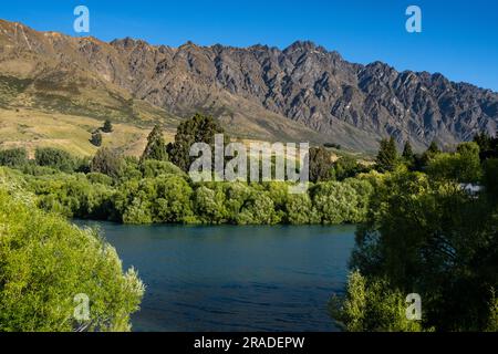 Die berühmten Remarkables Mountains liegen oberhalb des beliebten Radweges, der nördlich von Queenstown auf Neuseeland South Island verläuft. Foto: Rob Watkins Stockfoto