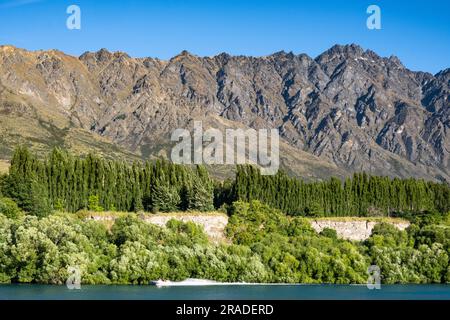 Die berühmten Remarkables Mountains liegen oberhalb des beliebten Radweges, der nördlich von Queenstown auf Neuseeland South Island verläuft. Foto: Rob Watkins Stockfoto