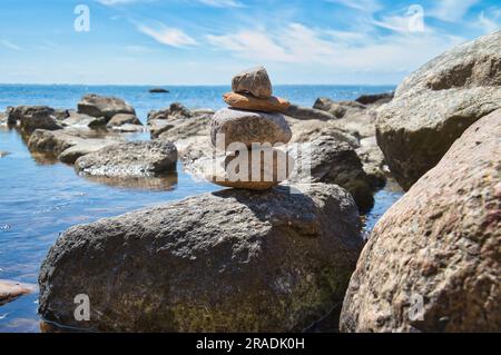 Steinpyramide an der Ostseeküste mit Blick auf das Meer in der Sonne. Spirituelle Sichtweise. Landschaftsaufnahmen von Poel Island Stockfoto