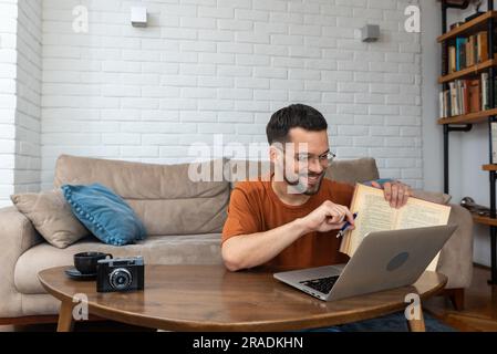 Ein junger, intelligenter Student, der zu Hause auf dem Boden sitzt und als freiberuflicher, entfernter Fremdsprachenprofessor arbeitet und den Leuten englisch beibringt Stockfoto