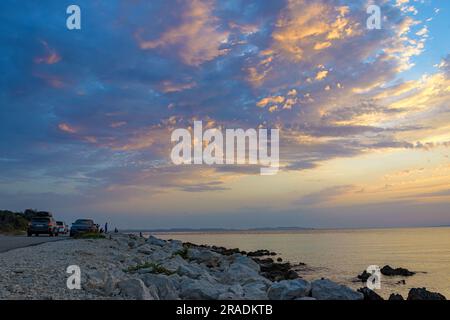Touristen bewundern den Sonnenuntergang auf der Insel Vir, Kroatien. Stockfoto