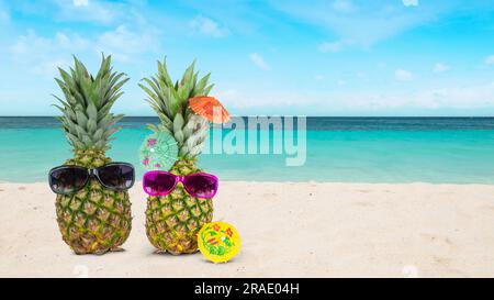 Ananas mit Sonnenbrille am Strand. Tropisches Urlaubs- und Flitterwochen-Konzept. Stockfoto