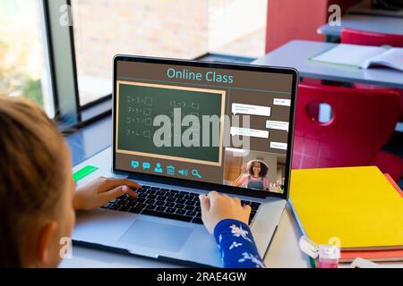 Vielfältiges Schulmädchen mit einer Lehrerin, die während eines Laptop-Videogesprächs Unterricht hat Stockfoto