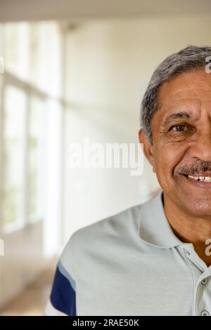 Ein halbes Porträt eines glücklichen älteren, birassischen Mannes zu Hause mit Kopierraum Stockfoto