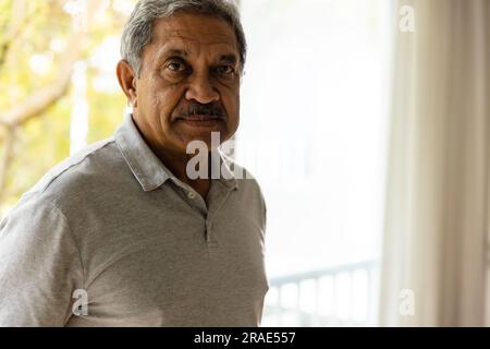 Porträt eines ranghöchsten birassischen Mannes, der am Fenster bleibt Stockfoto