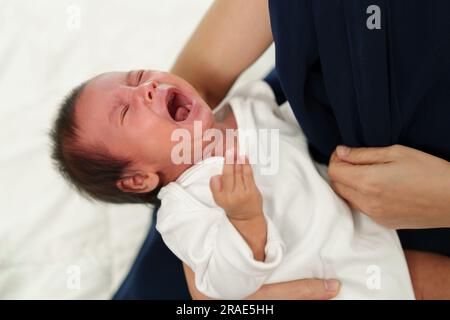 Neugeborenes weint, während die Mutter ein Bett hält Stockfoto