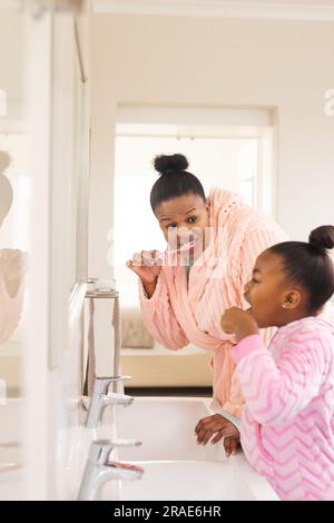 afroamerikanische Mutter und Tochter putzen Zähne im Badezimmer Stockfoto