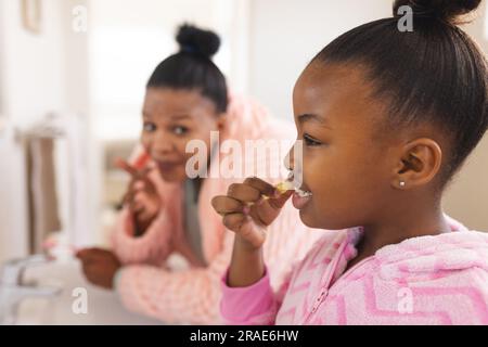 afroamerikanische Mutter und Tochter putzen Zähne im Badezimmer Stockfoto