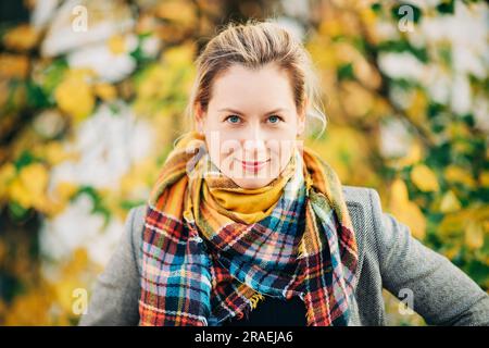 Herbstporträt einer schönen Frau mit farbenfrohem Schal im Freien Stockfoto