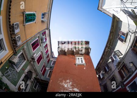 Koper, Slowenien. 2. Juli 2023. Blick aus der Fischperspektive auf einen alten Balkon inmitten der historischen Gebäude des Stadtzentrums Stockfoto