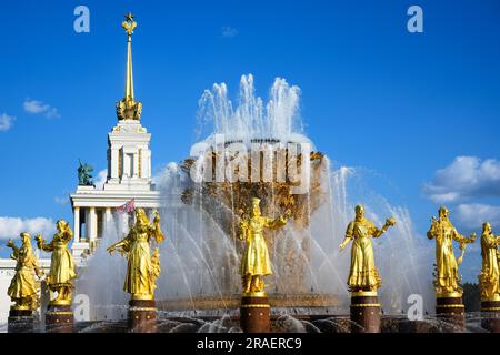 VDNKh Park, Peoples Friendship Fountain im Sommer, Moskau, Russland. Ein alter luxuriöser Brunnen mit goldenen Statuen im sowjetischen Design unter blauem Himmel, Wahrzeichen o Stockfoto