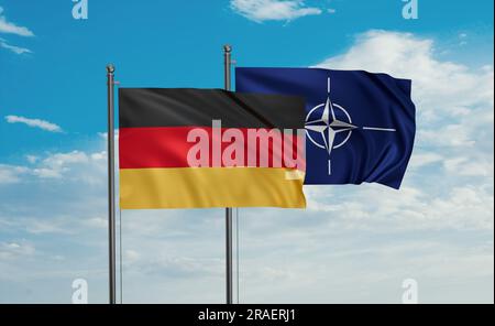 NATO-Flagge und deutsche Flagge, die zusammen auf blauem Himmel winken Stockfoto