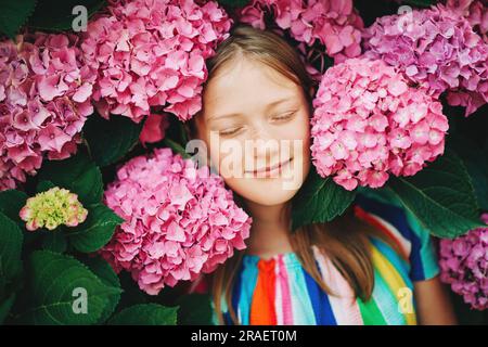 Hübsches Mädchen, Porträt mit rosa Hortensien. Augen zu Stockfoto