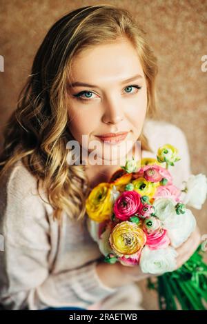 Porträt einer schönen jungen Frau mit bunten Butterblumen Stockfoto