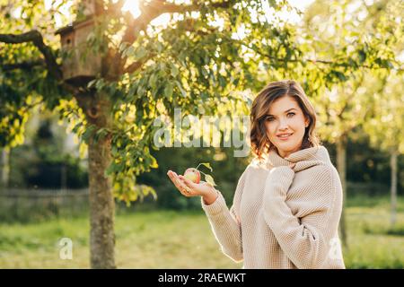 Außenporträt einer wunderschönen jungen Frau im Park, die einen warmen Strickpullover trägt Stockfoto