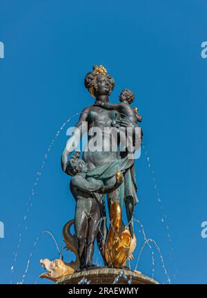 Kopenhagen, Dänemark - 15. September 2010: Nahaufnahme des Caritas-Brunnens mit Bronzestatue von Mutter und Kind auf Gammeltorv, isoliert gegen blauen Kragen Stockfoto