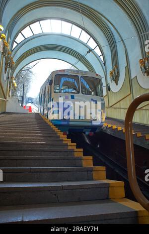 Kiew, Ukraine - 03.08.2023: Eine blau-weiße Seilbahn erhebt sich auf Schienen entlang des Hanges. Standseilbahn, Seitenansicht. Station Kiew, Ukraine Stockfoto