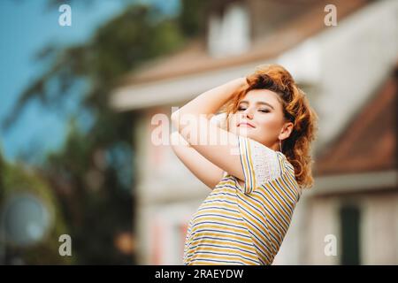 Außenporträt eines glücklichen Mädchens mit gestreiftem T-Shirt Stockfoto