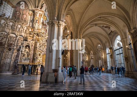 Das Innere der Kathedrale von Toledo, Blick auf die Menschen, die in dem riesigen gewölbten Ambulatorium der Kathedrale von Toledo stehen, und auf den Altar von El Transparente, Spanien Stockfoto