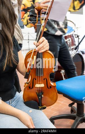 Echte junge Musikstudenten während der Proben. Musikinstrumente und Musikständer mit Stve. Violine, Trommeln, Viola, Flöte, Stockfoto