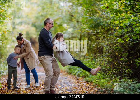 Glückliche Familie, die Spaß mit Kindern im Wald hat. Stockfoto