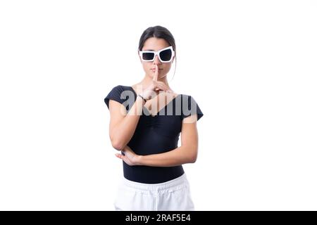 Studioporträt einer jungen braunen Modelin, die eine lustige, schicke weiße Sonnenbrille trägt. Stille Stockfoto