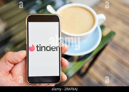 USA, Kalifornien - Juni 23 2023: Tinder Logo. Dating-App auf dem Bildschirm des Mobiltelefons. Mann, der Profile auf der Beziehungsseite oder in der Anwendung liest und gefällt Stockfoto