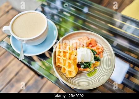 Kartoffelwaffeln, pochiertes Ei, Avocado-Sahne mit Lachs und Ei. Gesundes Frühstück, Eiweiß. Restaurant-Gericht. Stockfoto