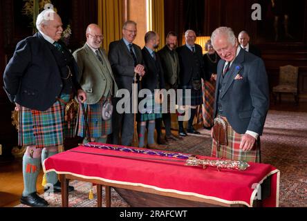 König Karl III. Mit Designer Mark Dennis (links) und dem neuen Elizabeth Sword im Palace of Holyroodhouse in Edinburgh. Das Schwert, benannt nach Königin Elizabeth II., wird Teil der Ehren von Schottland sein, zu denen die Krone und das Zepter gehören. Es wird dem König während des Nationaldienstes von Thanksgiving und der Einweihung in der St. Giles-Kathedrale am Mittwoch, den 5. Juli, überreicht. Foto: Montag, 3. Juli 2023. Stockfoto