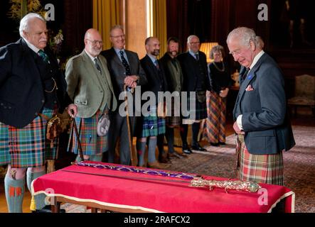 König Karl III. Mit Designer Mark Dennis (links) und dem neuen Elizabeth Sword im Palace of Holyroodhouse in Edinburgh. Das Schwert, benannt nach Königin Elizabeth II., wird Teil der Ehren von Schottland sein, zu denen die Krone und das Zepter gehören. Es wird dem König während des Nationaldienstes von Thanksgiving und der Einweihung in der St. Giles-Kathedrale am Mittwoch, den 5. Juli, überreicht. Foto: Montag, 3. Juli 2023. Stockfoto