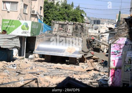 Dschenin, Besetztes Palästinensisches Gebiet. 03. Juli 2023. Ein israelischer militärischer Bulldozer räumt während einer israelischen Militäroperation im Flüchtlingslager Dschenin im besetzten Westjordanland am 3. Juli 2023 eine Straße. Mindestens 9 Palästinenser wurden bei einem israelischen Armeeangriff auf das Flüchtlingslager Dschenin im besetzten Westjordanland getötet und zwei Dutzend weitere verletzt, sagte das palästinensische Gesundheitsministerium am Montag. Foto von STR/UPI. Kredit: UPI/Alamy Live News Stockfoto