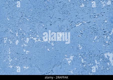 Betonwand mit alter gerissener, abblätternder blauer Farbe. Verwitterte raue lackierte Oberfläche mit Rissen- und Abblätterungsmustern, Grunge, gereifter Textur. Stockfoto