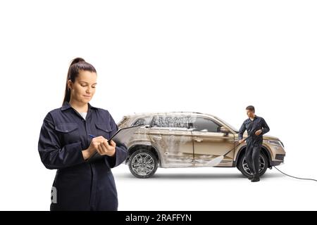 Eine Autowascherin, die ein Dokument schreibt, und ein Mann, der einen SUV mit einem auf weißem Hintergrund isolierten Hochdruckreiniger wäscht Stockfoto