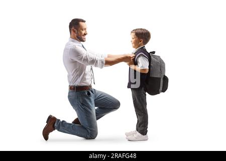 Profilaufnahme über die gesamte Länge eines Vaters, der seinem Sohn dabei hilft, sich auf die Schule vorzubereiten, isoliert auf weißem Hintergrund Stockfoto