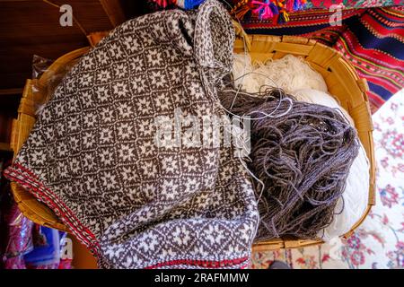 Von einem grauen pullover Garn und Faden zum Stricken closeup gestrickt. Stricken als Hobby. Zubehör für Stricken. Stockfoto