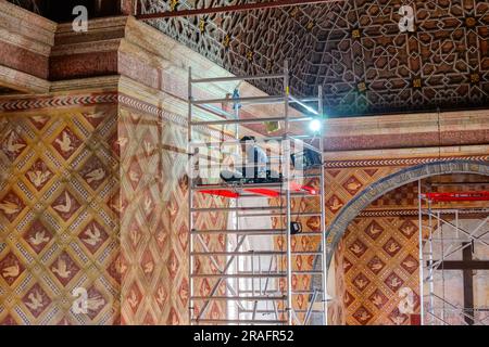 Ein Arbeiter restauriert das Taubenwandmotiv aus dem 15. Jahrhundert in der Palatinkapelle im Nationalpalast Sintra in Sintra, Portugal. Die romantischen architektonischen und märchenhaften Paläste ziehen Touristen aus der ganzen Welt an. Stockfoto