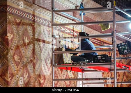 Ein Arbeiter restauriert das Taubenwandmotiv aus dem 15. Jahrhundert in der Palatinkapelle im Nationalpalast Sintra in Sintra, Portugal. Die romantischen architektonischen und märchenhaften Paläste ziehen Touristen aus der ganzen Welt an. Stockfoto