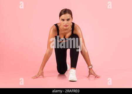 Sprint-Konzept. Porträt einer jungen Sportlerin in Startposition Stockfoto