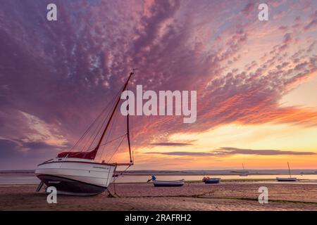 Ein spektakulärer Sonnenaufgang Ende Juni, wenn die Flut in Richtung der kleinen Boote schleicht, die die Flussmündung des Flusses Torridge bei Appledore in North Devon säumen. Stockfoto