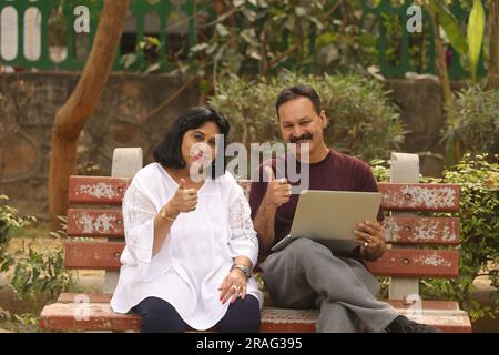 Wunderschönes Old Indian Happy Pair sitzt zusammen im Park und hat fröhliche Momente im Leben. Gemeinsame Urlaubsplanung. Stockfoto