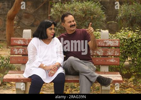 Wunderschönes Old Indian Happy Pair sitzt zusammen im Park und hat fröhliche Momente im Leben. Stockfoto