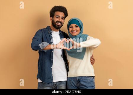 Portrait von romantischen muslimischen Paar macht Herz Geste mit ihren Hände Stockfoto