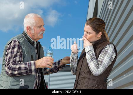 Junge Bauarbeiterin, die Zigarette raucht Stockfoto