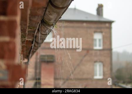 Eine Dachrinne in einem Gebäude, eine alte Abflussrohrnaht, Wasser fließt durch verfaultes Metall, es gibt einen Platz für eine Inschrift. Hochwertiges Foto Stockfoto