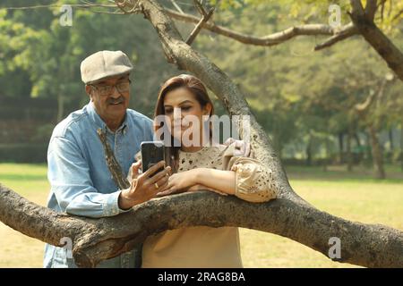 Ein älteres indisches Paar, das eine gute romantische Zeit im Green Park hat. Sie genießen, lächeln und haben fröhliche Momente. Stockfoto