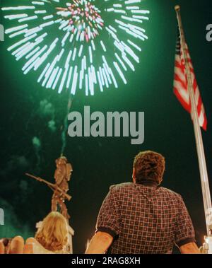 Gary O'connell (rechts) und seine Frau Diane O'connell aus Dayton, OH, sehen Sie während der Lakefest Fourth of July Celebration am Samstag, den 3. Juli 1999 in Jamestown, Russell County, KY, eine Explosion von Feuerwerk über dem Monument Square und einer „Spirit of the American Doughboy“-Statue. USA. Mr. O'connell sagte, die Familie besitzt eine Hütte am Lake Cumberland und macht seit vielen Jahren Urlaub in Russell County. (APEX MediaWire Foto von Billy Suratt) Stockfoto