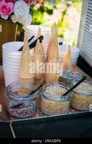 Eiswaffel, Tassen und Streusel bei der Sommerparty im Garten. Stockfoto