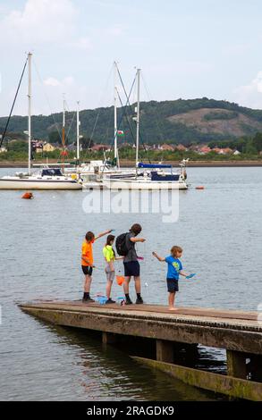 Kinder genießen einen Tag am Meer beim Fischen von Krabben vor dem Hafen im North Wales Resort in Conway Stockfoto