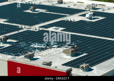 Draufsicht der durch den Hurrikan Ian zerstörten Photovoltaik-Solarpaneele, die auf dem Dach des Industriebaues zur Erzeugung von ökologischem Strom montiert sind Stockfoto